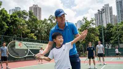 Coach teaching junior serve technique at Victoria Park