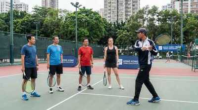 Coach demonstrating backhand at Victoria Park