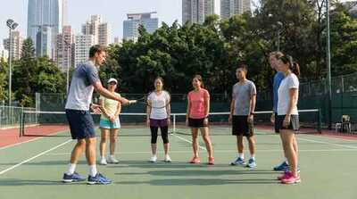 Coach demonstrating stroke to adults at Victoria Park